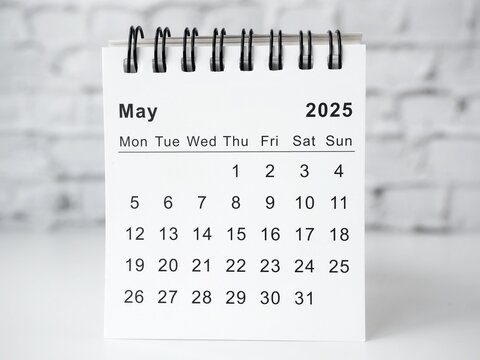 May 2025 white monthly desk calendar on a table
