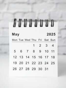 May 2025 white monthly desk calendar on a table