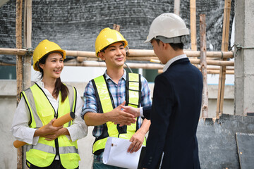 A project manager greets construction workers on-site with a handshake, fostering strong relationships and team morale and building trust and collaboration to ensure project success