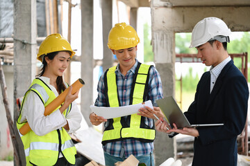 Fototapeta premium A project manager reviews blueprints with construction workers, discussing progress and plans on-site