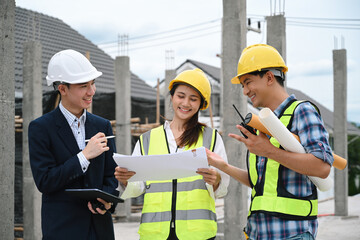 Engineer and workers collaborate outdoors, reviewing blueprints and discussing project progress