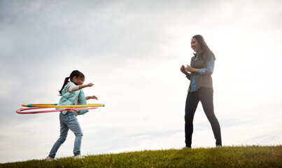 Child, countryside and hoop with woman and clapping, support and babysitter for holiday activity. Childcare, love and plastic ring with female person, autumn and nanny for cloudy sky in field © ReeseArcurs/peopleimages.com