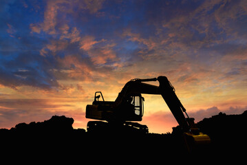 Crawler excavators silhouette are digging the soil in the construction site. on  sunset background