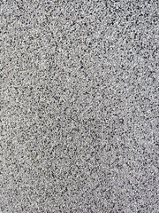 close-up texture shot of a rough, grey surface reminiscent of concrete or stucco. The granular quality and uneven shade variation make it suitable for backgrounds, graphic design