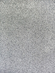 close-up texture shot of a rough, grey surface reminiscent of concrete or stucco. The granular quality and uneven shade variation make it suitable for backgrounds, graphic design