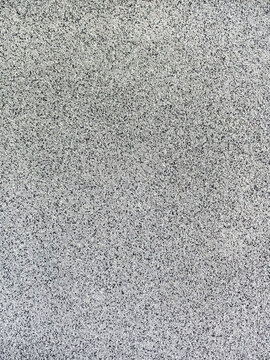 close-up texture shot of a rough, grey surface reminiscent of concrete or stucco. The granular quality and uneven shade variation make it suitable for backgrounds, graphic design