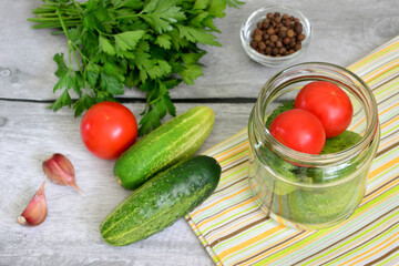 a jar with tomatoes and cucumbers, preserving vegetables for winter