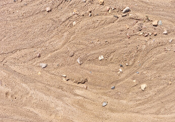 Sand on the beach as an abstract background. Sand deposits after water flow. Texture. Pattern. Selective focus