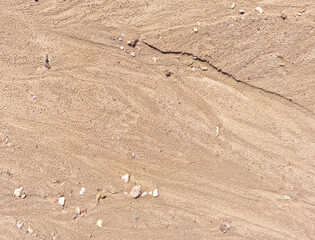 Sand on the beach as an abstract background. Sand deposits after water flow. Texture. Pattern. Selective focus