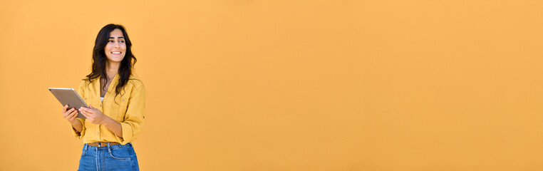 20s middle eastern freelance businesswoman using tablet pc for work isolated on yellow background....