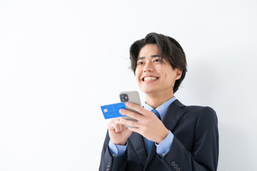 クレジットカードとスマートフォンを使うビジネス男性