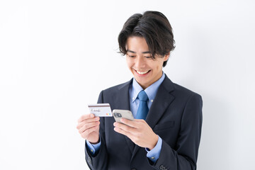 クレジットカードとスマートフォンを使うビジネス男性