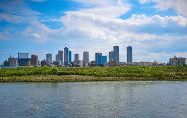 Obraz premium 河川敷からみたビル群と青空