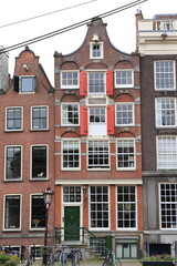 Fototapeta premium Amsterdam Brouwersgracht Canal House Facade with Red Wooden Shutters, Netherlands