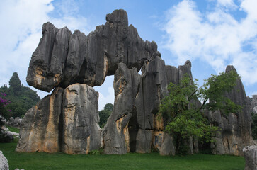 The scenery of the  stone forest in Kunming city, Yunnan, China, showing a large rock formation with a hole in the middle. 