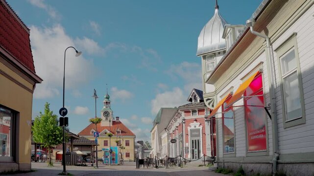 Pori Cityscape on a Sunny Summer Day With a Clock Tower	A view of Pori's city center on a clear summer day, showcasing a clock tower, historic buildings, and a bustling street. Pedestrians and cyclist