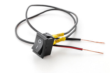 small switch button connected to DC wires, on white background