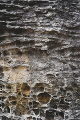 Empty dark grey rough stone wall on cave for abstract  background and texture. beautiful patterns, space for work, banner, wallpaper close up.