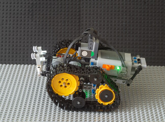 Obraz premium The robot drives on the gray surface.Teaching children robotics using toys.
