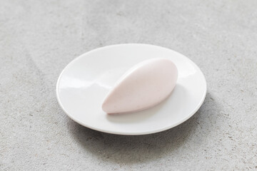 Vanilla Cream quenelle, on a plate. Close up. Light gray background