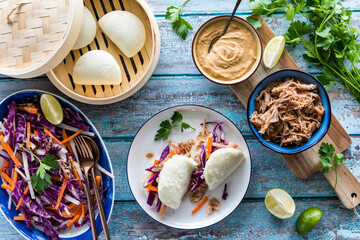 Stuffed pulled pork bao buns with cabbage slaw and peanut sauce.