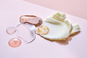 Different cosmetic textures on a delicate peach background. 