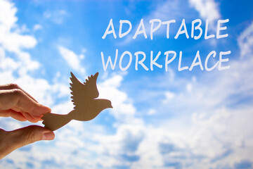 Adaptable workplace symbol. Concept words Adaptable workplace on beautiful sky. Beautiful blue sky cloud background. Businessman hand with wooden bird. Business Adaptable workplace concept. Copy space