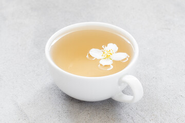 Green Tea with jasmine in a white cup. Light gray background