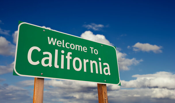 Naklejki Welcome To California Green Road Sign Over Blue Sky with Some Clouds.