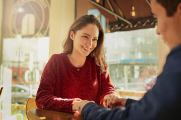 Restaurant, table and happy couple holding hands with love on anniversary, date and empathy with...