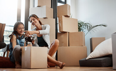 Mother, child and help with packing boxes for new home with moving, mortgage investment or property relocation. Woman, daughter and support with tape for cardboard package or real estate in apartment