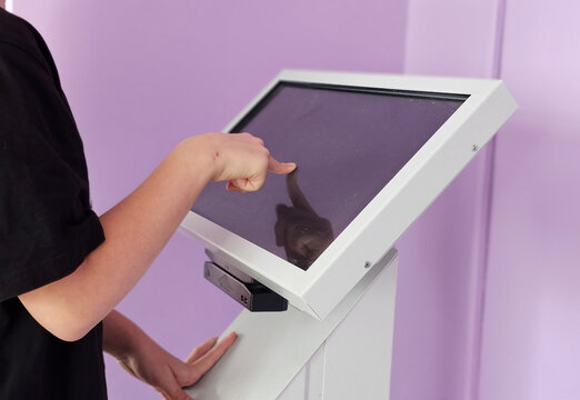Person Using a Touchscreen Kiosk in a Purple Room