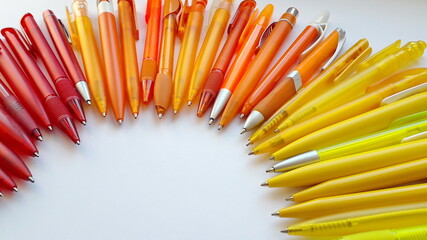  Orange fountain pens on a light background. Stationery office supplies. Orange handles.