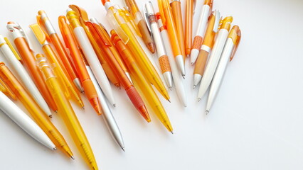  Orange fountain pens on a light background. Stationery office supplies. Orange handles.