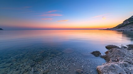 A tranquil bay with calm, shallow waters, the sunset creating a gradient of warm colors across the sky.