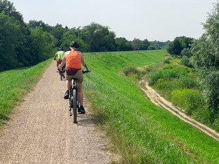 Rear View of Cyclists Riding Electric Bikes on Gravel Road