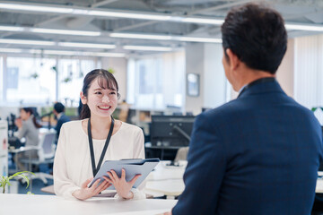 窓口で来客の対応をする女性スタッフ