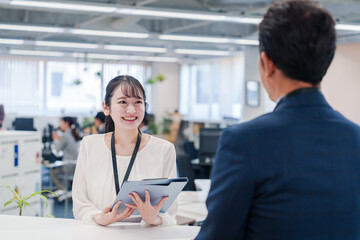 窓口で来客の対応をする女性スタッフ