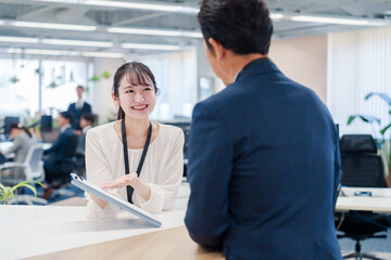 窓口で来客の対応をする女性スタッフ