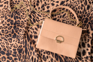 Peach fuzz color natural leather bag on fashionable leopard print fabric .