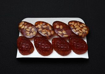 Marmalade in the form of forest cones. Marmalade with pine nuts on a substrate.