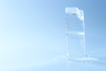 Blocks of clear ice on light blue background, space for text