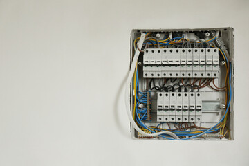 Fuse box with many electric meters and wires on light wall, space for text