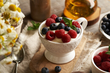 Cottage cheese blended with flax seed oil in a bowl, with fresh raspberries and blueberries