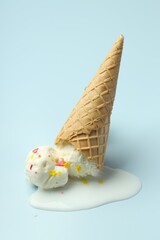 Melted ice cream in wafer cone on light background
