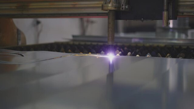 Close up of cutting plasma separating programmed material shape. Machinery in engineering production.