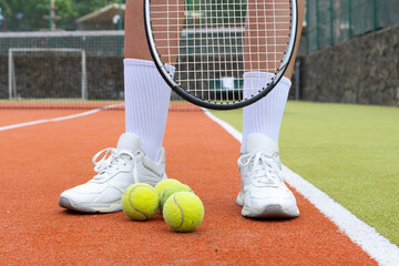 
Close up on racket and ball on tennis court.