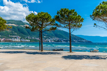 A view past trees towards the far seafront at Vlore in Albania in summertime
