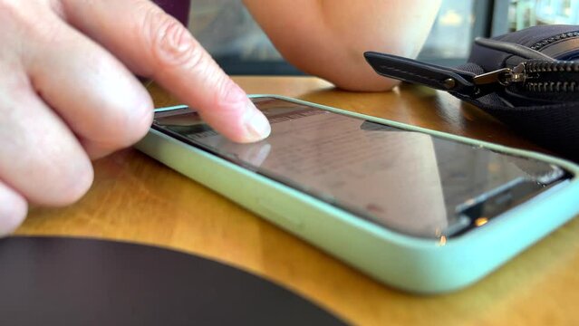 Person at restaurant scrolling through web results on phone
