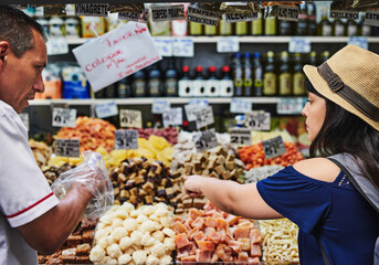 Woman, customer and helping in supermarket, service and select food products or organic groceries. People, man and support consumer in shopping at store, choice and assistance with purchase or trade